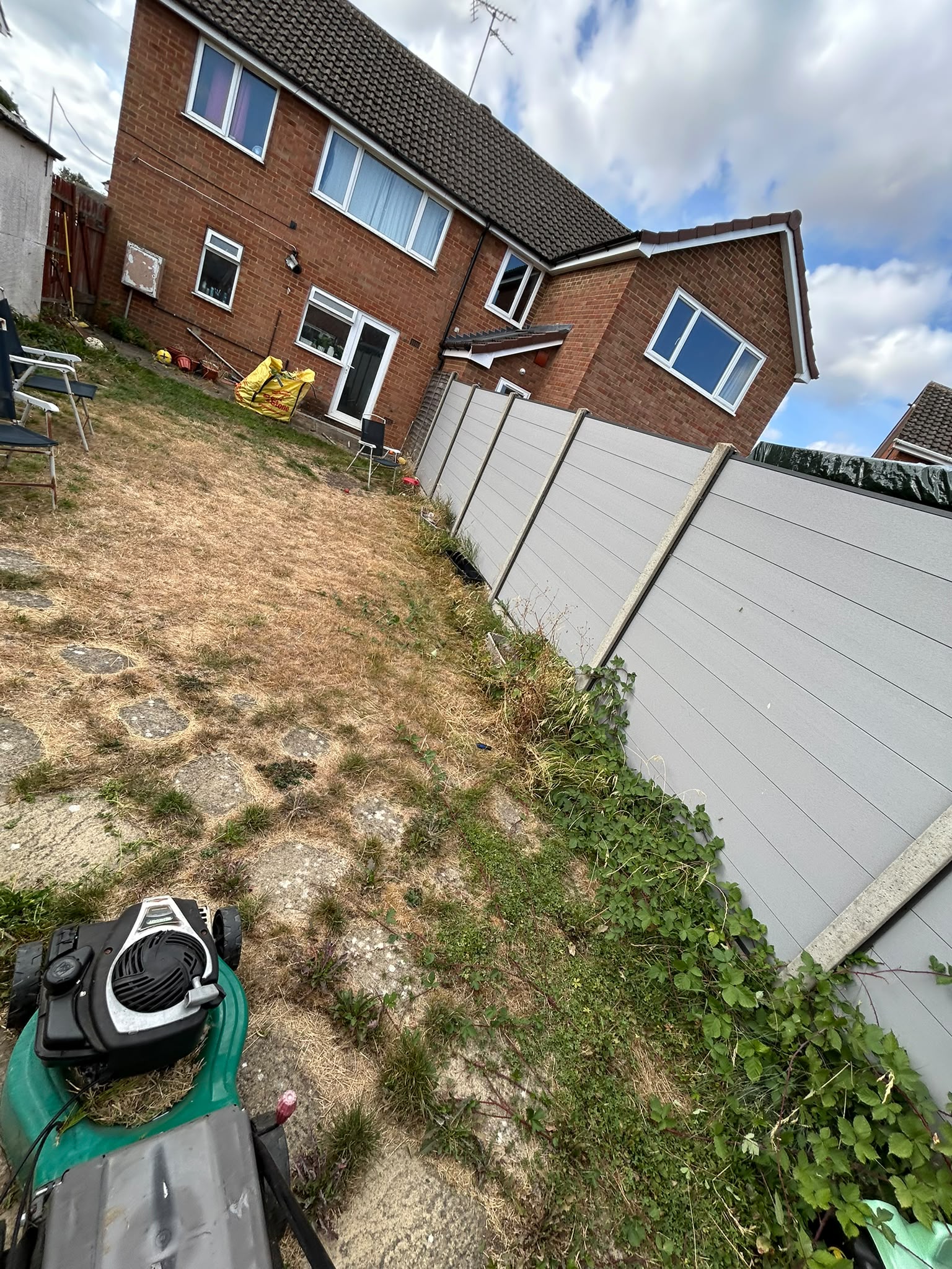 A dry, tired sloped rear lawn cleared and mown down alongside new fencing